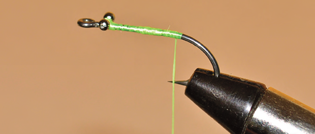 1. Set the hook in the vise and sharpen as necessary. 2. Start the thread between 1/8-inch and ¼-inch behind the hook eye. At about ¼-inch behind the eye set the bead chain eye on top of the hook shank and with a figure eight crossing of the thread wrap it in tightly and then make several courses under the bead chain to tighten the eyes. Wrap the thread to the bend of the hook. Tie in six or seven strands of Krystal Flash leaving an inch or so extending behind the hook bend. Tie in the tip end of the V-rib so that when it is wrapped forward the curved side is on the outside. Wrap the thread forward to the front of the bead chain. Twist the Krystal Flash and wrap it tightly to the front of the eyes and tie it off on the hook point side of the shank. Trim the butt ends of the flash at the bend of the hook about ½-inch long. 