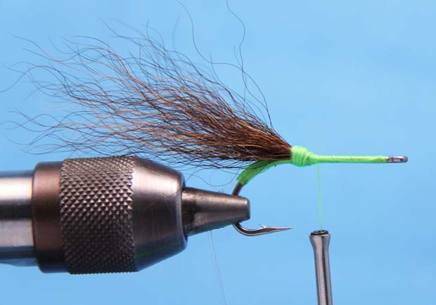 2. Cut a pencil-size hank of Bucktail measuring slightly longer than the shank of the hook, and remove any loose hair or under fur. Tie in the bundle at the point of the hook. 