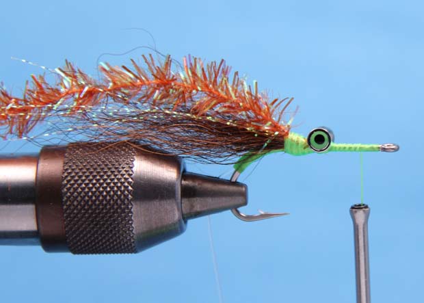 4. On top of the the bucktail, tie in a 6 inch piece of Crystal Chenille with several tight wraps and advance the tread to about an 1/8 of an inch behind the eye of the hook. 