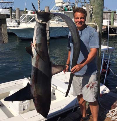 New York Gov. Andrew Cuomo just for the boast of it, catches and kills a 154.5-pound thresher shark, an endangered species. The shark? Thrown in the dumpster. Photo credit www.grindtv.com.