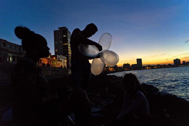 Cuban fisherman ties inflated condoms together and attaches them to his fishing line. “Condoms” keep his bait high in the water and increase his line’s resistance. Malecon sea wall, at sunset in Havana, Havanna, Cuba. Photo Associated Press.