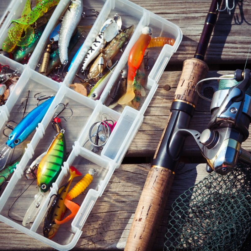 Fishing Lures in tackle boxes with spinning rod and net