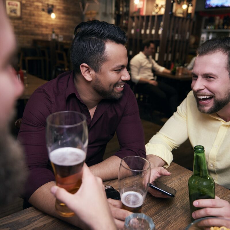 Male friends chilling with drinks at the bar