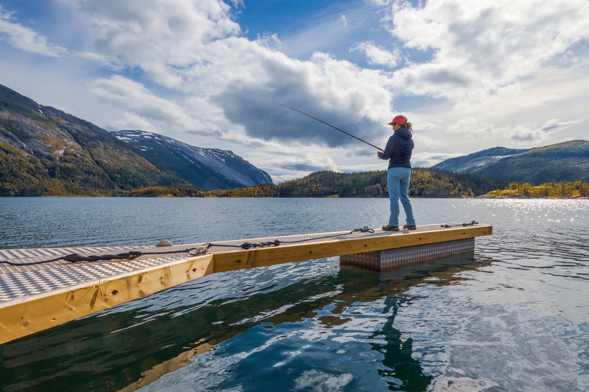 Woman fishing on Fishing rod spinning in Norway.
