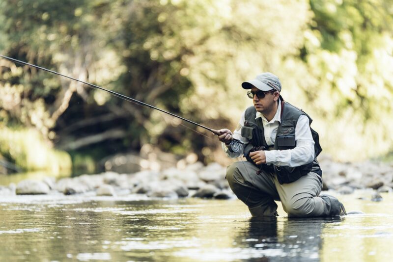 Fly fisherman using flyfishing rod.