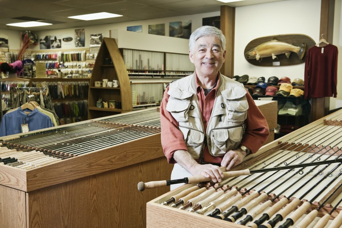 Portrait of an Asian American senior male owner of a retail fly- fishing shop