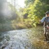 A fly fisherman casting for trout in a small freestone river in northeastern USA.