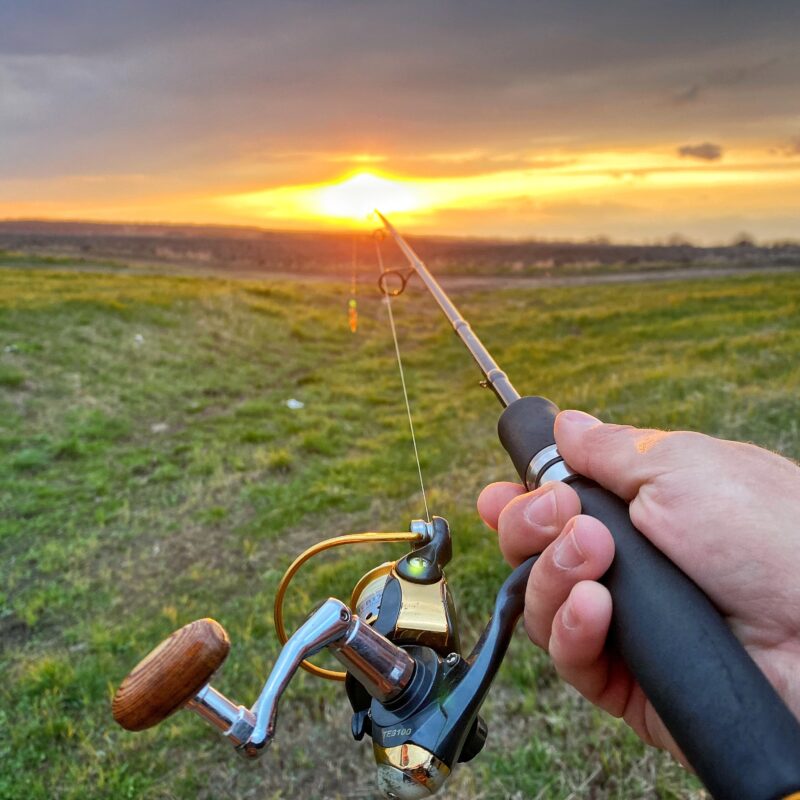 Fly fishing. Spinning in the hands. Fishing at sunset