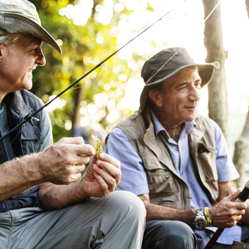Senior friends fishing by the lake